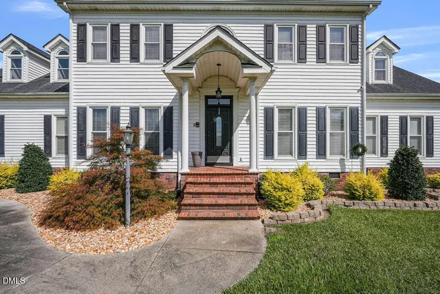 a view of a green field with house in the background