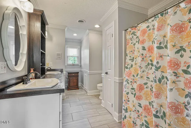 an aerial view of a house with outdoor space and trees all around