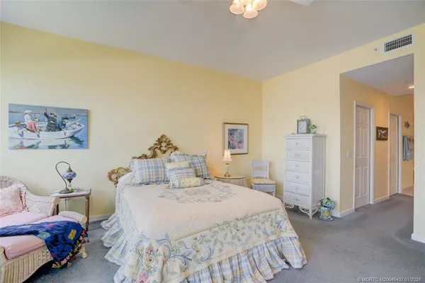 a spacious bedroom with a bed and a chandelier