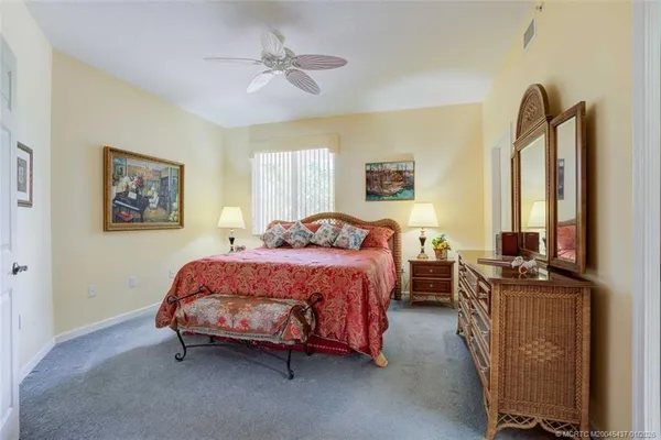 a bedroom with a bed and a lamp on dresser