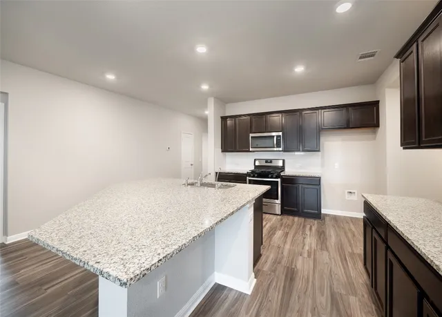 a kitchen with granite countertop stainless steel appliances and wooden cabinets