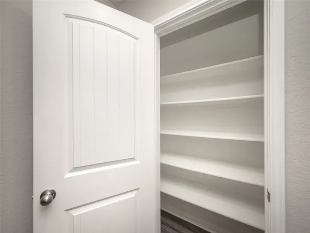 a view of walk in closet with empty racks