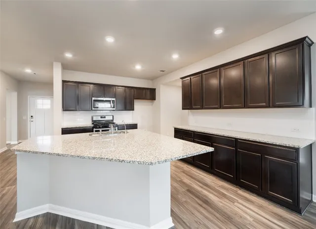 a kitchen with stainless steel appliances a sink stove and cabinets