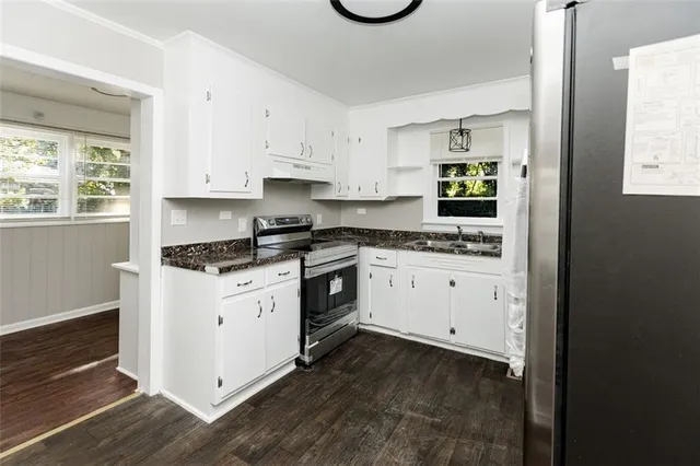 a kitchen with granite countertop white cabinets and white appliances