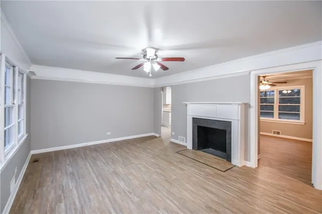 wooden floor fireplace and windows in an empty room