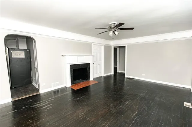 a view of a livingroom with wooden floor and a fireplace
