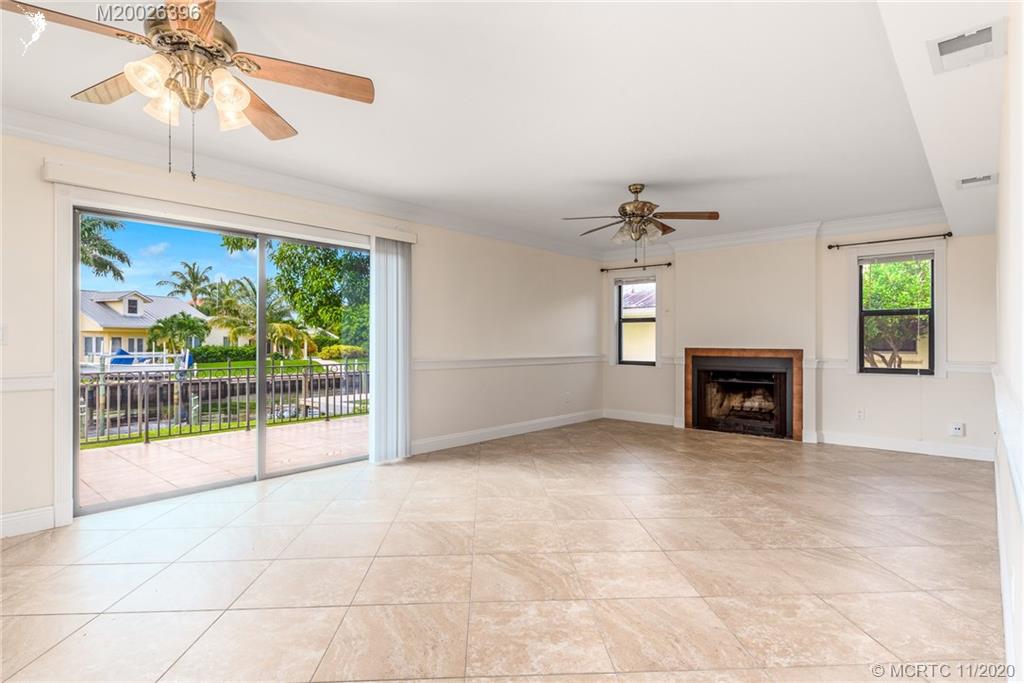 1239 Southwest Dyer Point Road Palm City, FL 34990 - Photo 13 of 34 a view of an empty room with a fireplace and a window