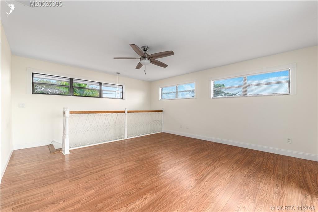 1239 Southwest Dyer Point Road Palm City, FL 34990 - Photo 19 of 34 a view of a big room with wooden floor and windows