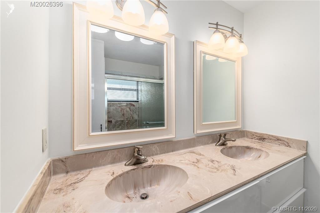 1239 Southwest Dyer Point Road Palm City, FL 34990 - Photo 23 of 34 a bathroom with a sink and a mirror