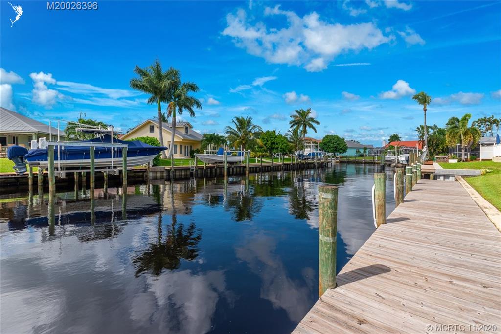1239 Southwest Dyer Point Road Palm City, FL 34990 - Photo 25 of 34 a view of a lake with a table and chairs