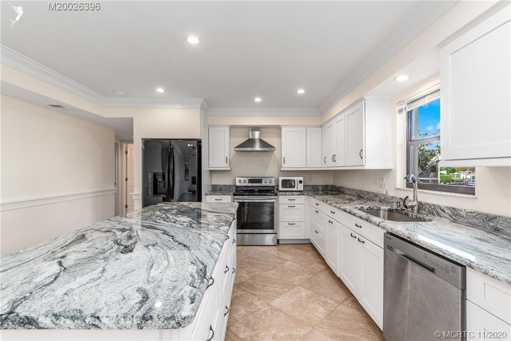 1239 Southwest Dyer Point Road Palm City, FL 34990 - Photo 8 of 34 a large kitchen with stainless steel appliances granite countertop a stove a sink and a refrigerator