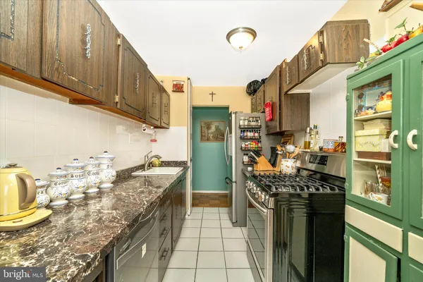 a kitchen with granite countertop a sink a stove and wooden cabinets