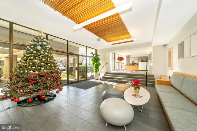 a room with lots of white furniture and a chandelier