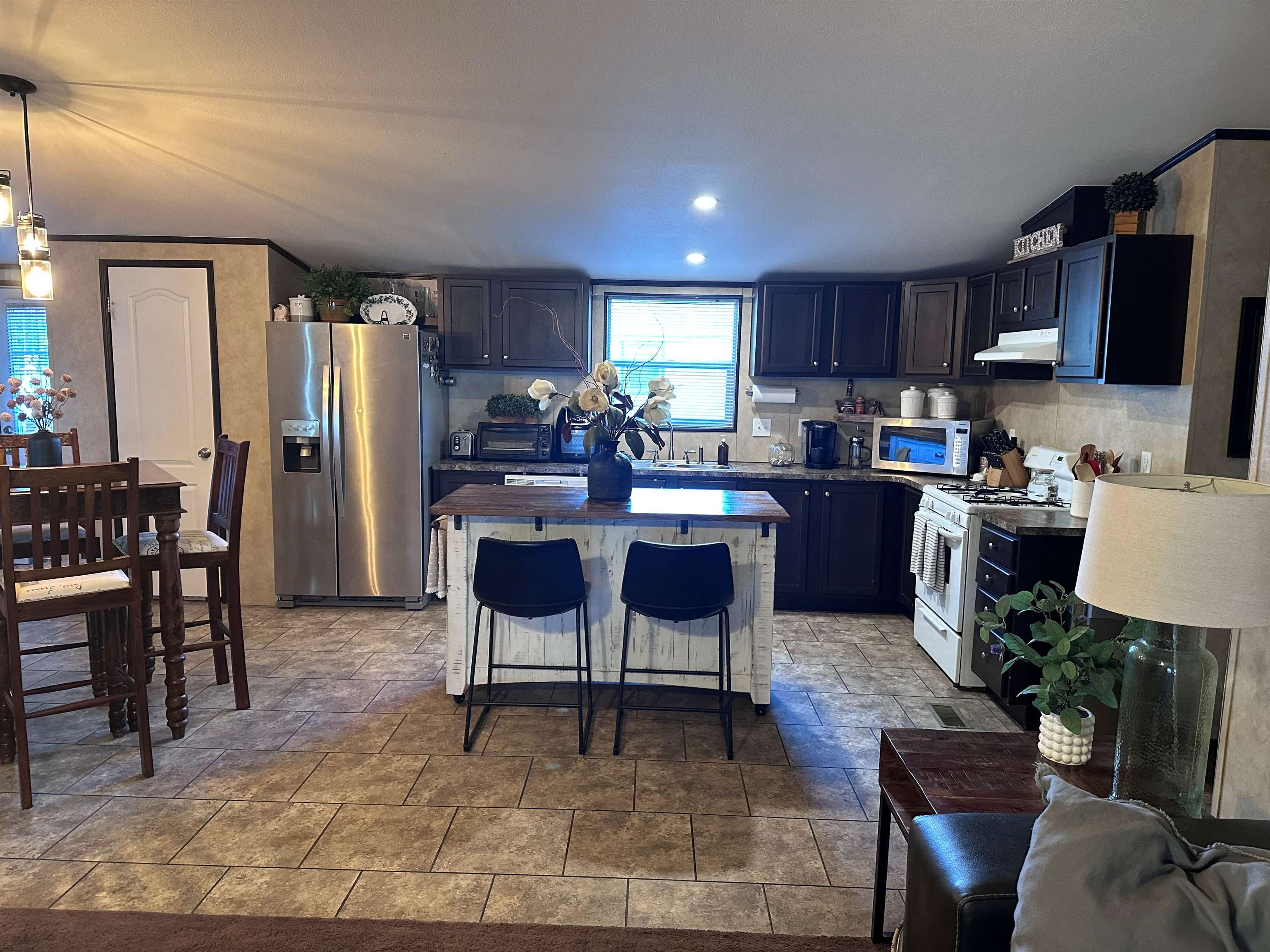 585-25 25 1/2 Road, Unit 125 Grand Junction, CO 81505 - Photo 8 of 24 a open dining room with stainless steel appliances kitchen island granite countertop a table chairs microwave and sink