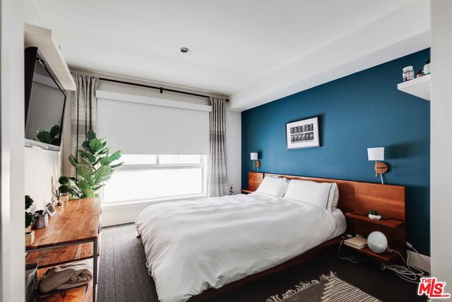 a bedroom with a large bed and a potted plant