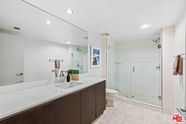 a bathroom with a double vanity sink toilet and shower