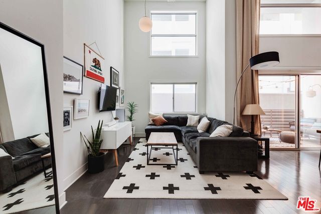 a living room with furniture a large window and a flat screen tv