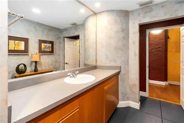 a spacious bathroom with a tub sink and mirror