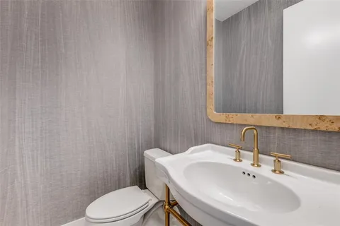 a bathroom with a sink a toilet and mirror