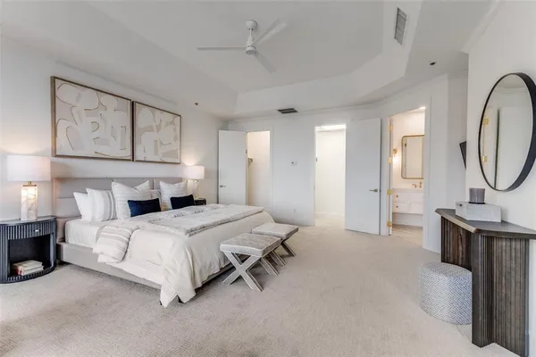 a bedroom with a bed a mirror and lamp