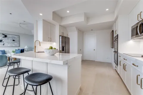 a kitchen with stainless steel appliances a sink a stove a refrigerator and cabinets