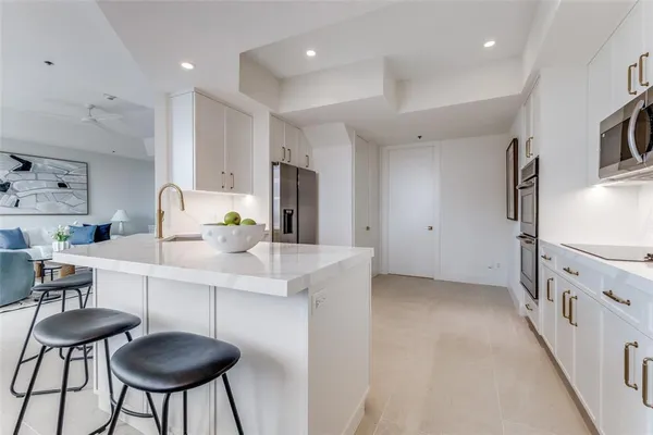 a kitchen with stainless steel appliances a sink a stove a refrigerator and cabinets