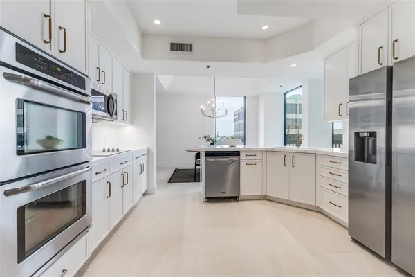 a kitchen with stainless steel appliances kitchen island granite countertop a stove a sink and a refrigerator