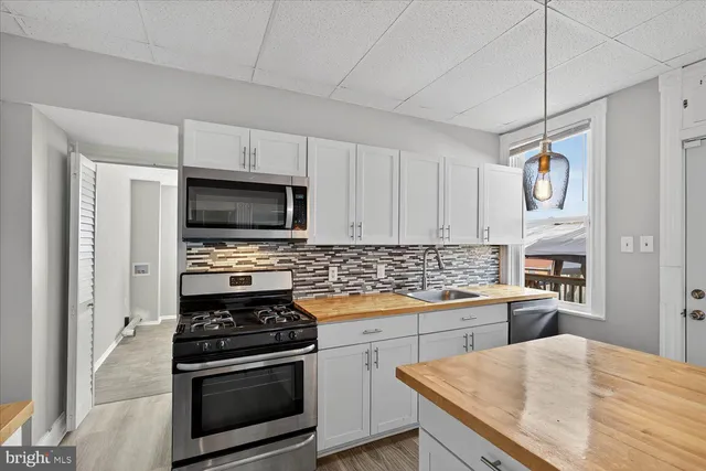 a kitchen with stainless steel appliances granite countertop a refrigerator a stove and a sink