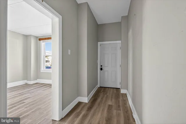 a view of a hallway with wooden floor and entryway