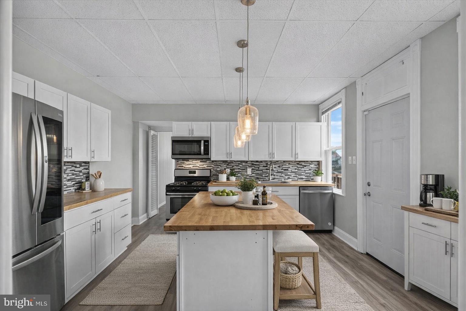 934 North Queen Street York, PA 17404 - Photo 6 of 35 a kitchen with a refrigerator a stove a sink dishwasher and white cabinets with wooden floor
