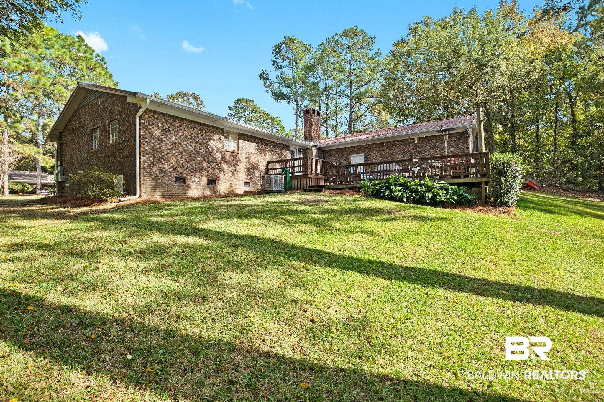 4 Rally Road Spanish Fort, AL 36527 - Photo 32 of 41 Rear view of house with crawl space, a deck, brick siding, a lawn, and a chimney