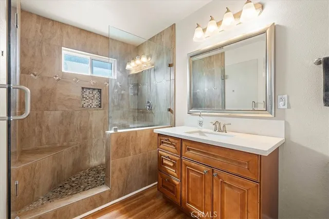 a bathroom with a sink vanity granite shower and a mirror