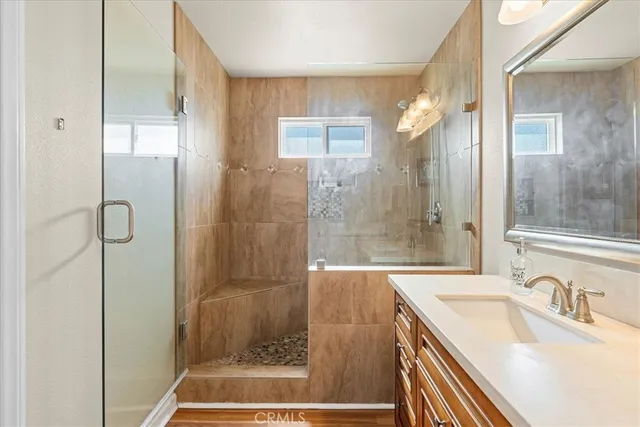 a bathroom with a granite countertop sink a shower and a mirror