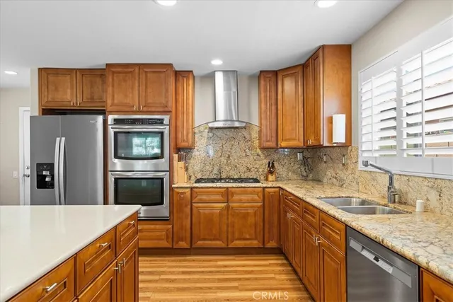 a kitchen with stainless steel appliances granite countertop a sink stove and refrigerator