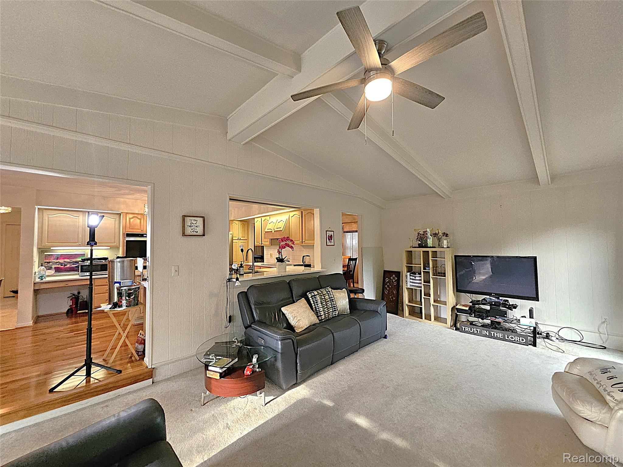 1114 Chaffer Drive Rochester, MI 48306 - Photo 24 of 50 Expansive living area featuring vaulted ceilings with exposed beams, a ceiling fan, and carpet flooring