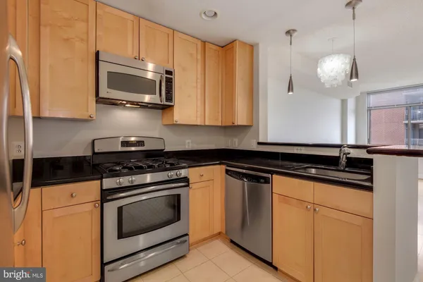 a kitchen with stainless steel appliances granite countertop a sink a stove and cabinets
