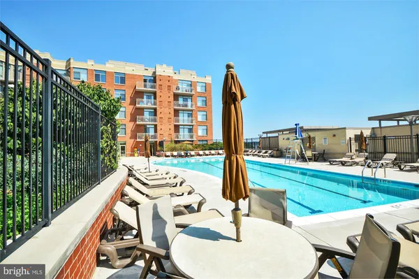 a view of a patio with lawn chairs floor to ceiling window and wooden fence