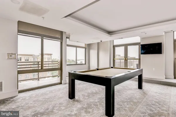 a room with furniture pool table and windows
