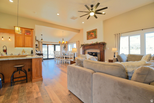 656 South Bullion Canyon Road Marysvale, UT 84750 - Photo 14 of 57 Living room featuring a fireplace, light wood-type flooring, recessed lighting, lofted ceiling, and a chandelier