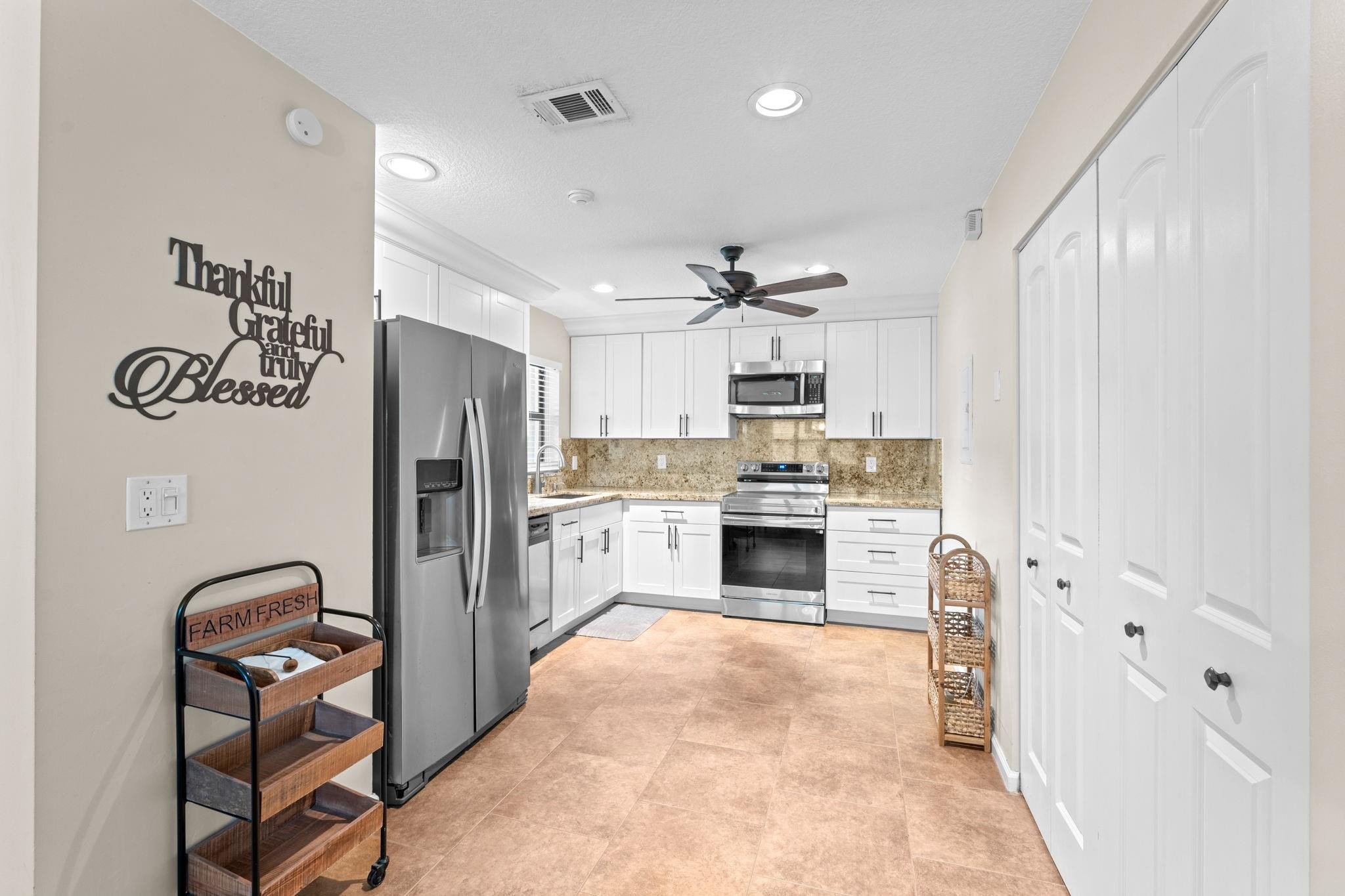 9601 Riverside Drive, Unit A6 Coral Springs, FL 33071 - Photo 12 of 25 a kitchen with stainless steel appliances a refrigerator sink and cabinets