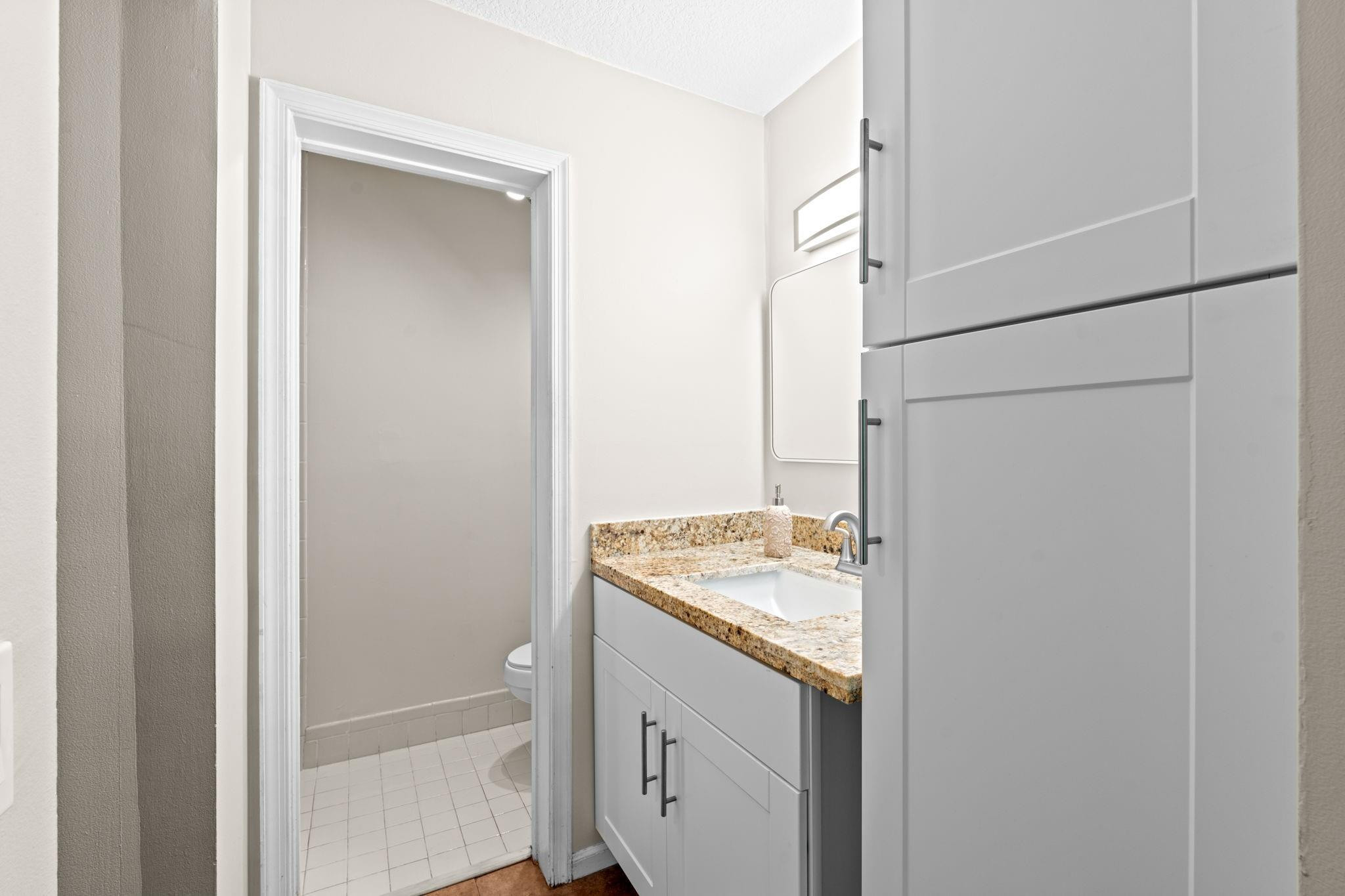 9601 Riverside Drive, Unit A6 Coral Springs, FL 33071 - Photo 15 of 25 a bathroom with a granite countertop sink and a mirror