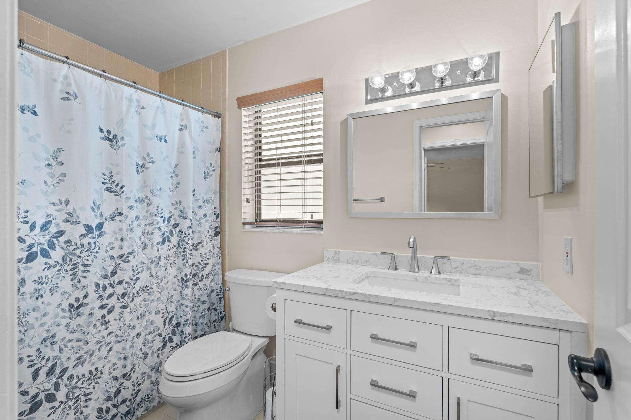 9601 Riverside Drive, Unit A6 Coral Springs, FL 33071 - Photo 16 of 25 a bathroom with a toilet sink and mirror