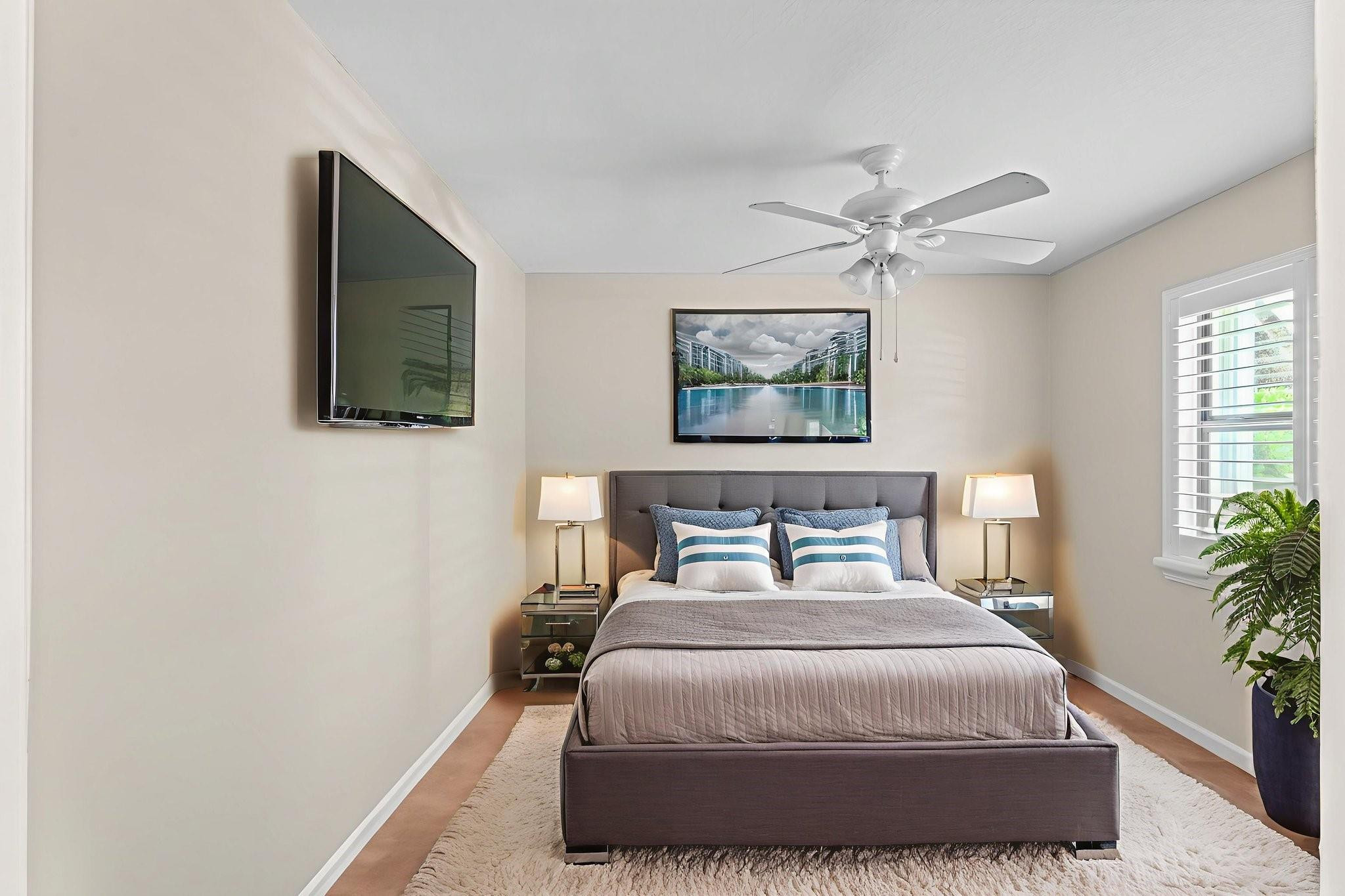 9601 Riverside Drive, Unit A6 Coral Springs, FL 33071 - Photo 17 of 25 a bedroom with a bed a painting on the wall and a potted plant