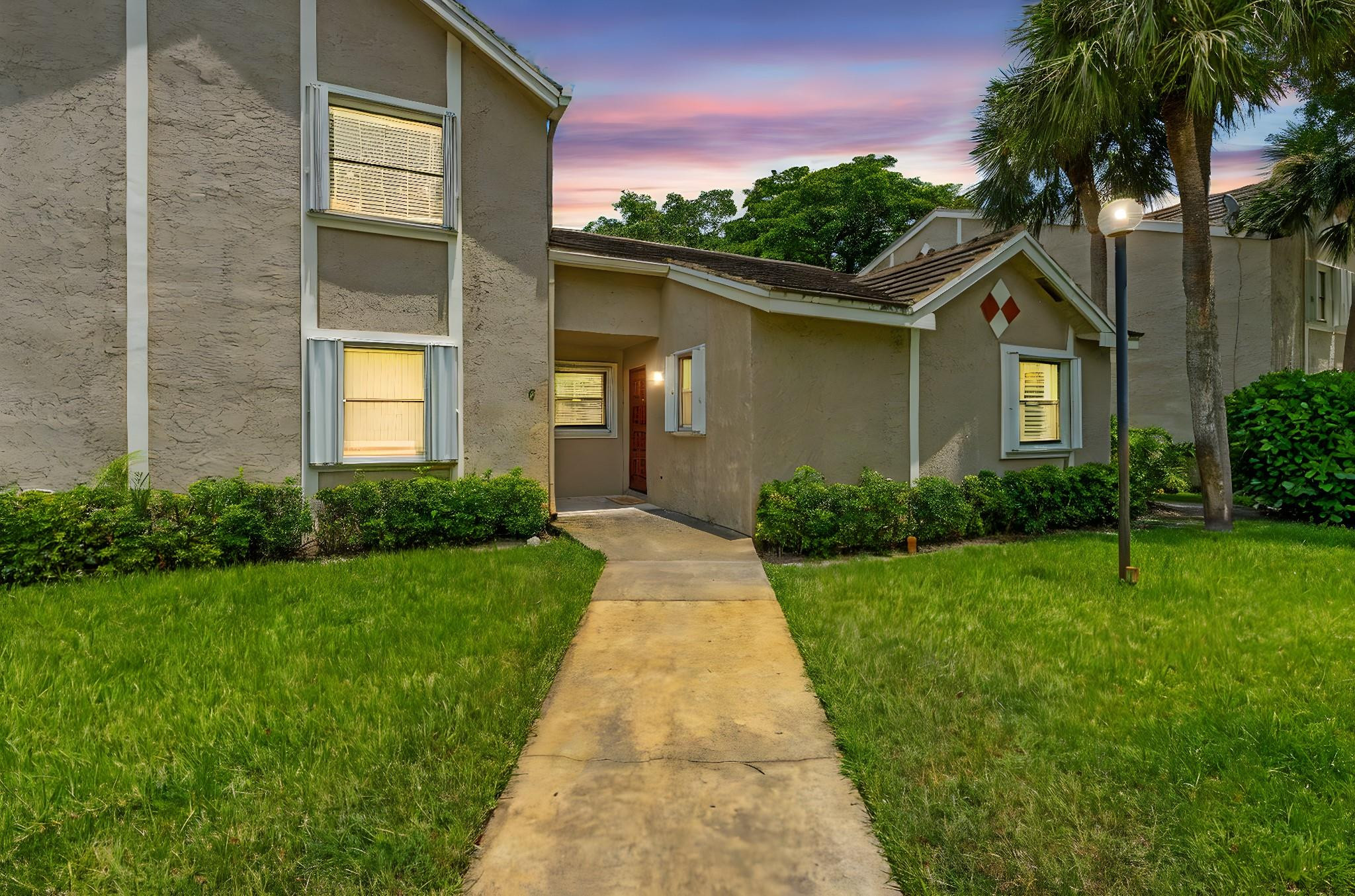 9601 Riverside Drive, Unit A6 Coral Springs, FL 33071 - Photo 2 of 25 a front view of a house with a yard