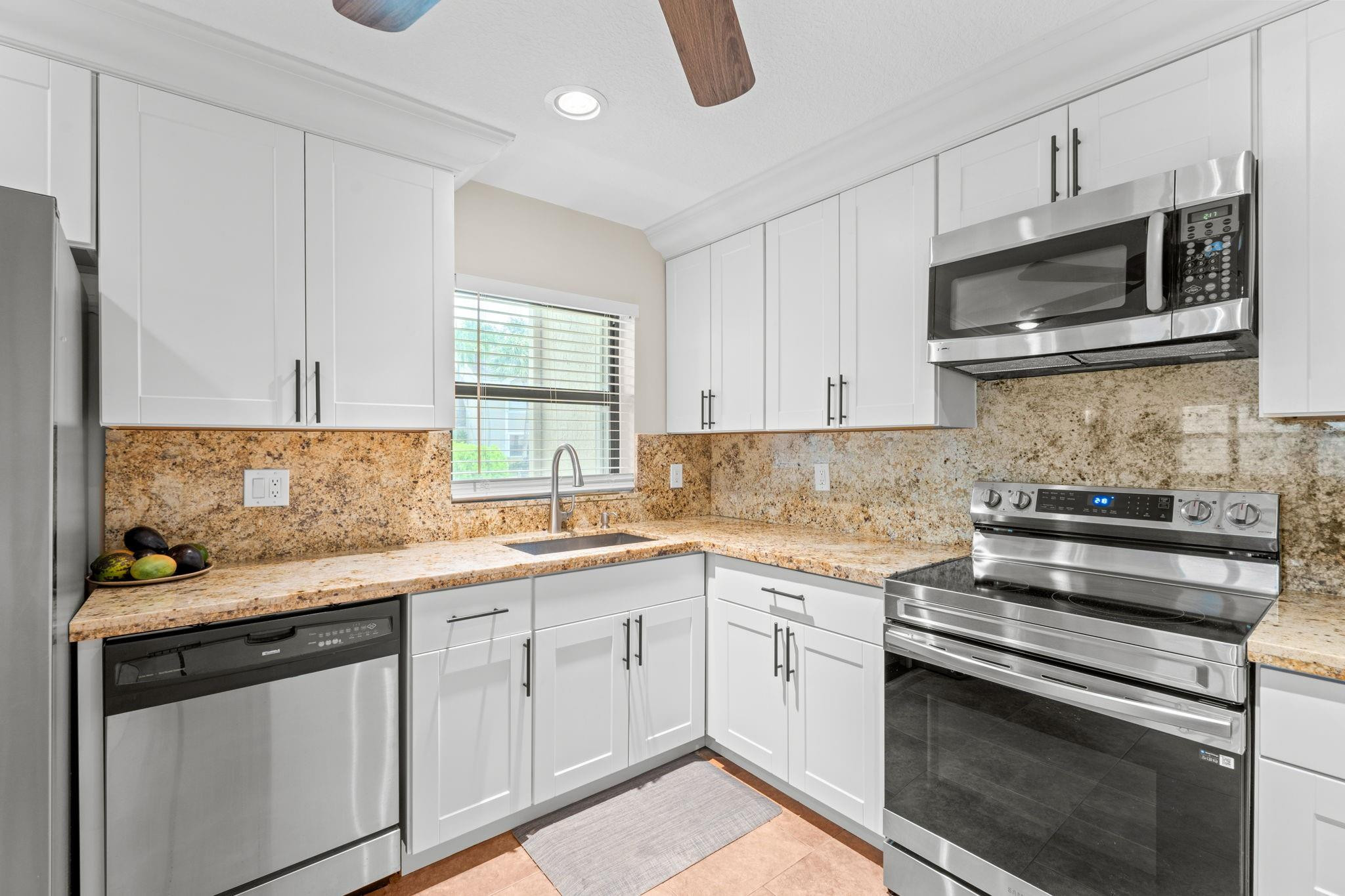 9601 Riverside Drive, Unit A6 Coral Springs, FL 33071 - Photo 10 of 25 a kitchen with stainless steel appliances granite countertop a sink and a stove