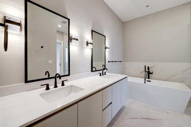 a bathroom with a bathtub shower sink and mirror
