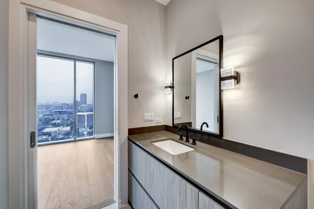 a bathroom with a granite countertop sink toilet a mirror a vanity and shower