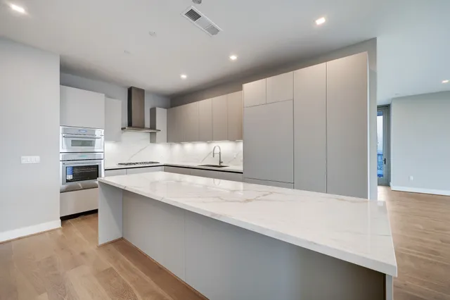 a view of a kitchen with a refrigerator and a stove top oven