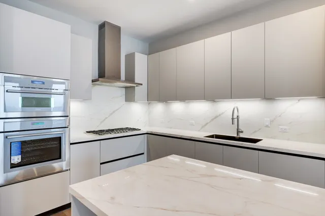 a kitchen with granite countertop white cabinets and white appliances