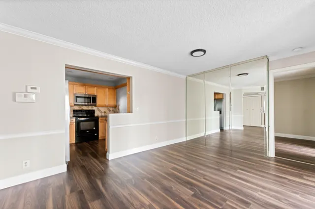 a view of empty room with wooden floor